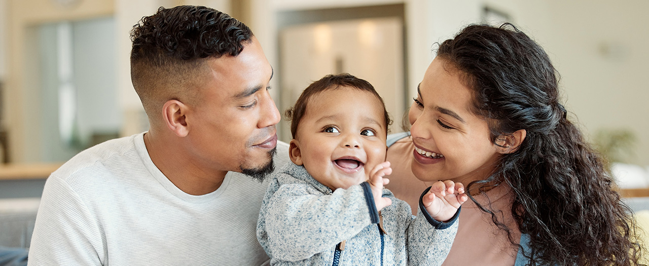 Father and mother smiling at their child.